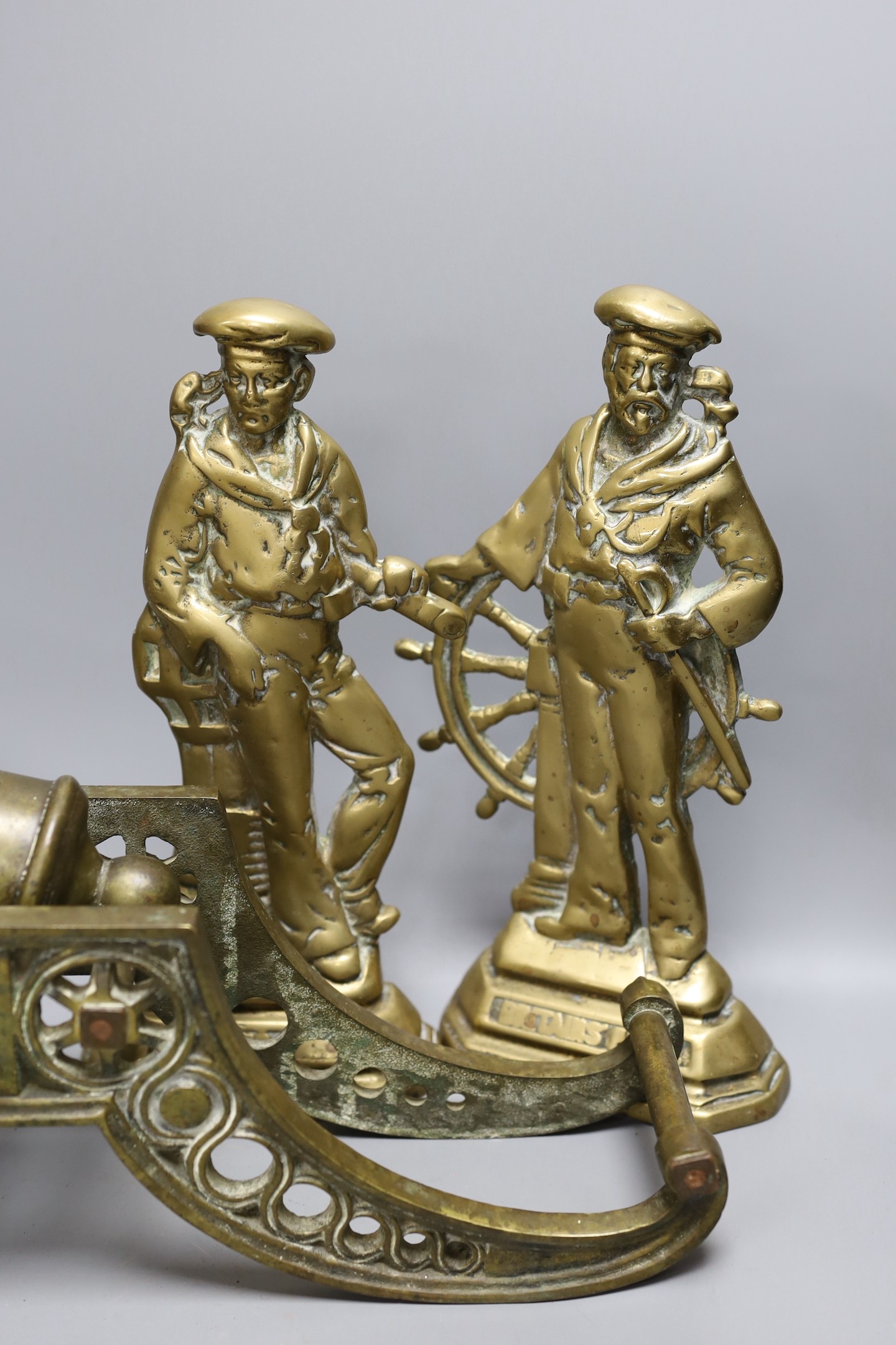 A cast bronze model of a cannon and a pair of cast brass sailors, cannon length 45cm